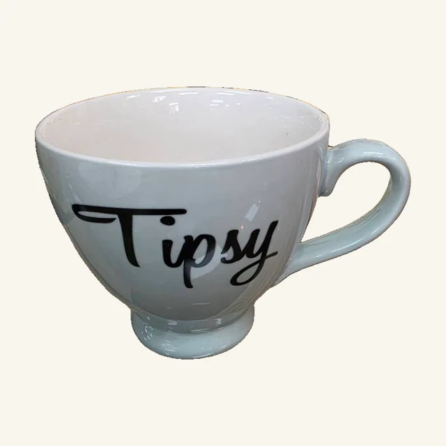 Pale blue footed stoneware mug with the original black script word Tipsy