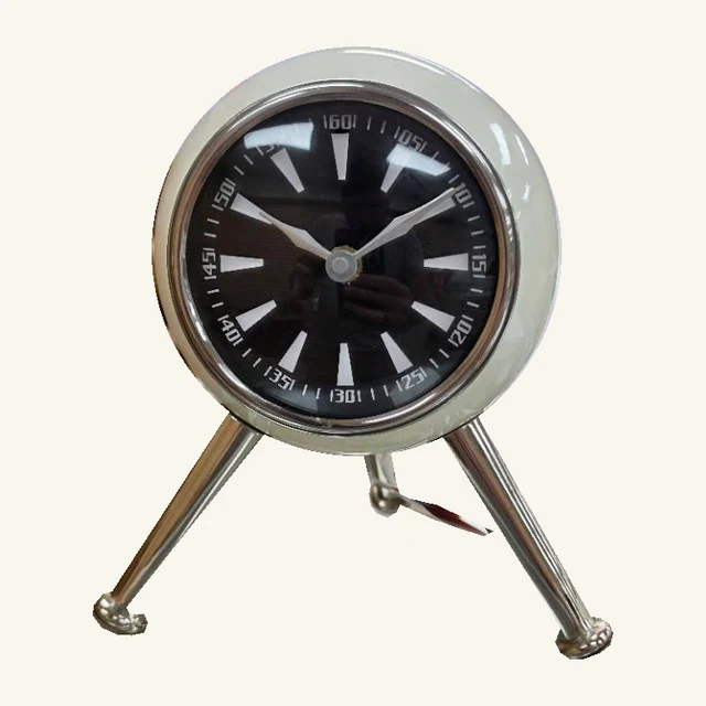 Complete white round table clock with black printed dial, original hands, three polished legs, flared feet and attached tag cord