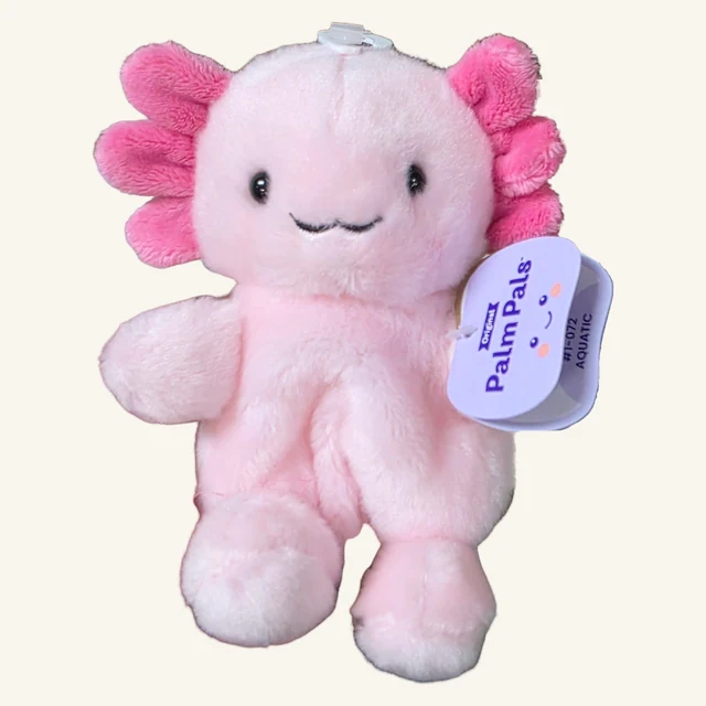 Actual pale-pink Ax axolotl plush with bright pink gills, original crown fastener and complete folded Palm Pals tag