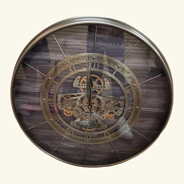 Complete round Bethel wall clock with a wood-look plank face, Roman numerals, slender spokes, central gears and a metal-tone outer rim.