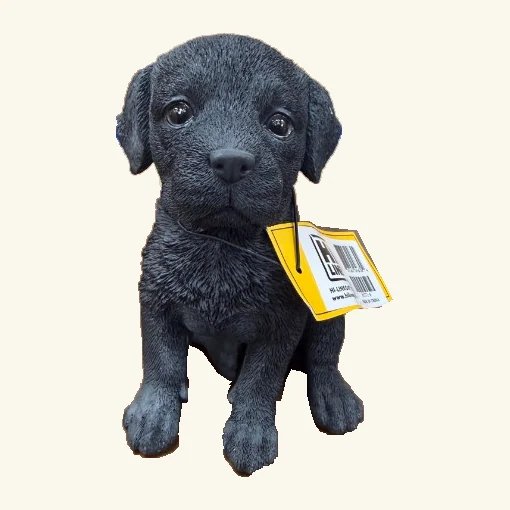 Sitting black Labrador puppy figurine with its complete head, ears, paws and original tag with white sticker overhang.