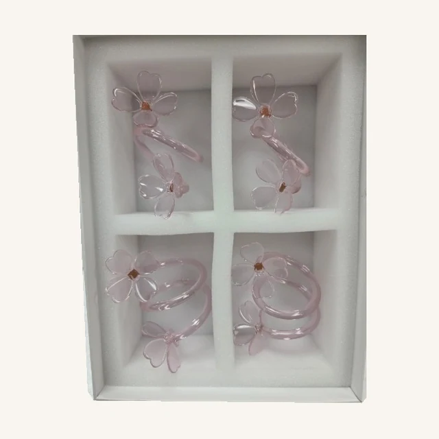Botanica Pink Glass Flower Napkin Rings — Set of Four. Set a welcoming table with four pink glass napkin rings shaped into delicate flower-like loops.