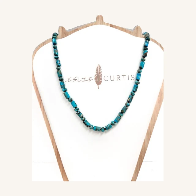 Briley necklace with irregular blue-green beads and small spacers on its original Leslie Curtis display