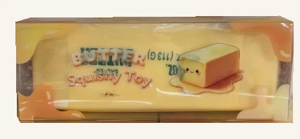 One yellow butter-shaped squishy toy in its complete original Butter Squishy Toy retail box.