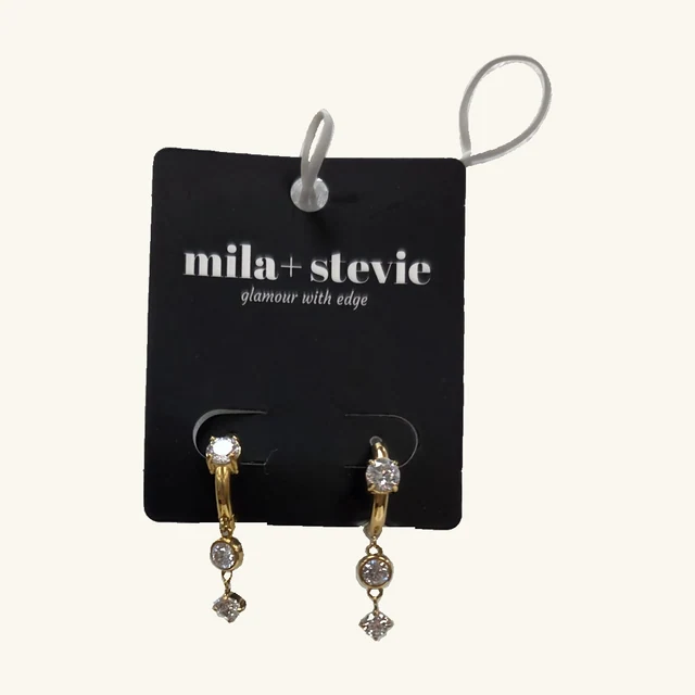 Complete pair of gold-tone Celeste CZ drop earrings with clear stones on the original black mila+stevie card, with both white display fasteners retained
