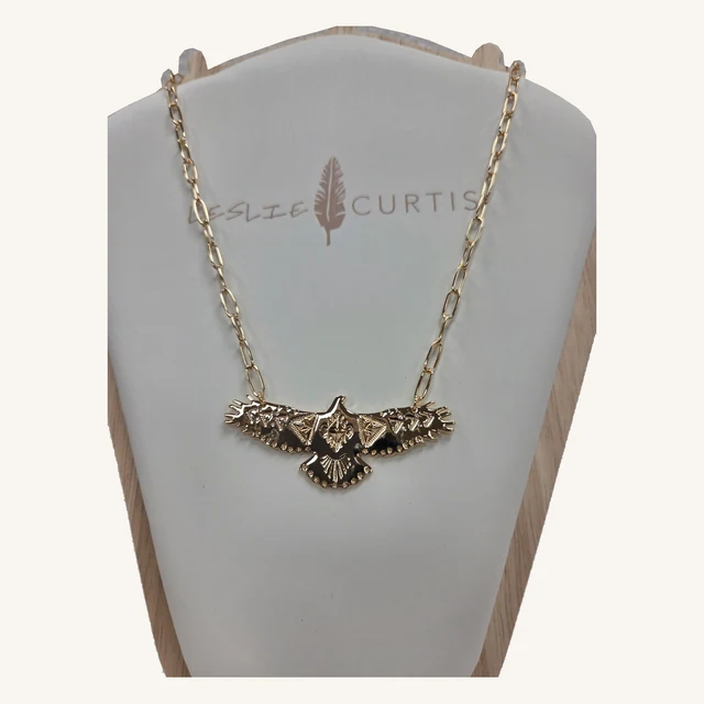 Cheyenne gold-tone eagle necklace with engraved details and tiny clear-stone accents on its original Leslie Curtis display