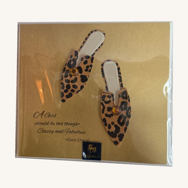 Gold-toned NIQUEA.D birthday card with two dimensional leopard-print shoes, gem accents and Classy and Fabulous wording, shown in its clear sleeve.