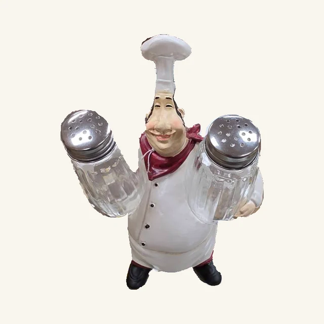 One smiling chef with a tall white hat and red neckerchief holding two upright silver-capped glass shakers