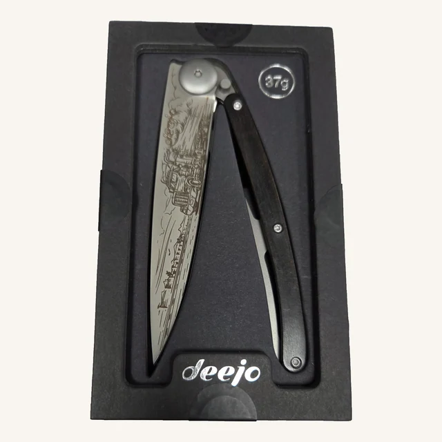 Deejo American Truck 37g folding knife with an engraved truck-scene blade and ebony-wood handle in its black presentation tray
