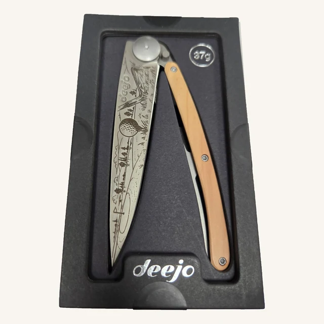 Deejo Golf 37g folding knife with an engraved golf-course blade and juniper-wood handle in its black presentation tray