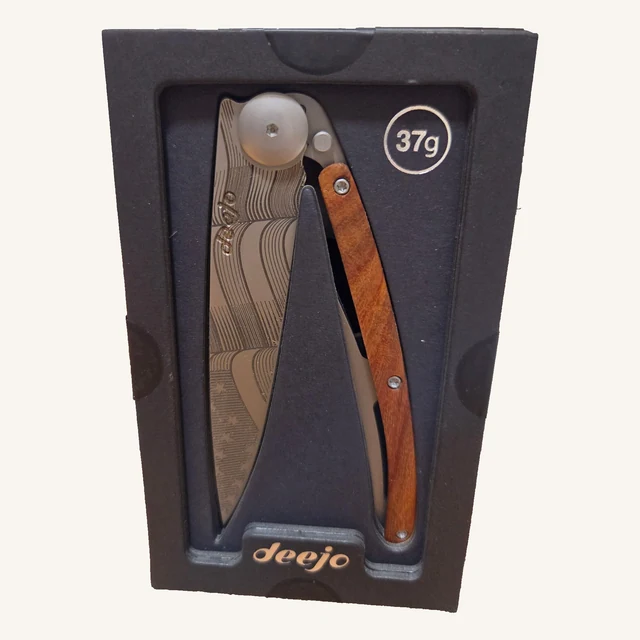 Deejo Stars & Stripes 37g folding knife with an engraved American-flag blade and coral-wood handle in its black presentation tray