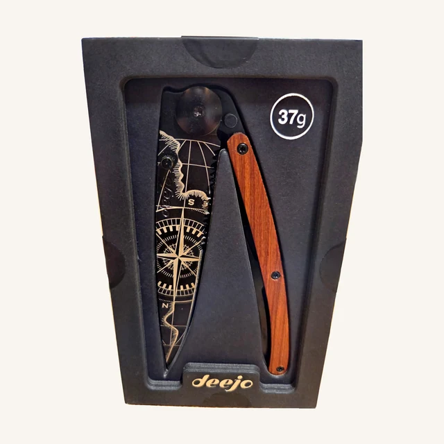 Deejo Terra Incognita Knife — 37g, Coral Wood. A map-inspired blade design and warm coral-wood handle give this serrated folding knife its travel-minded character.