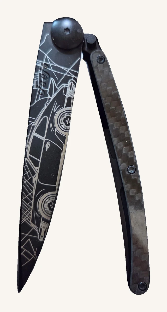 Actual Deejo Young Timer folding knife with classic-car linework on its dark blade, carbon-fiber handle and original pivot and screws