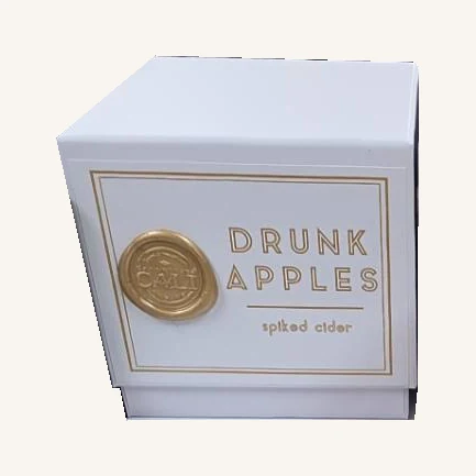 The actual closed Drunk Apples candle retail box with its gold lettering, seal and spiked cider wording