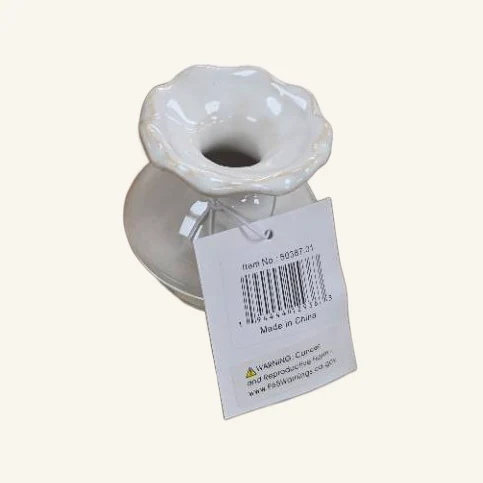 Actual single white Esperanza ceramic bud vase with its flower-shaped rim and original printed tag