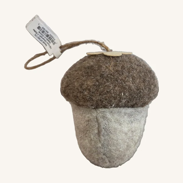 One light neutral felt acorn ornament with brown cap, complete hanging loop and attached supplier tag.