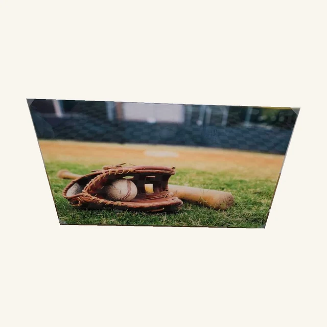 Field of Dreams. A baseball, glove and bat rest on the grass in a nostalgic tribute to time at the ball field.