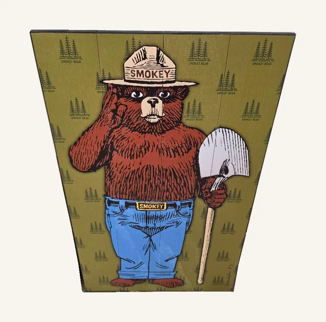 Full-length Smokey Bear wood sign with ranger hat, shovel, printed trees and original lettering.