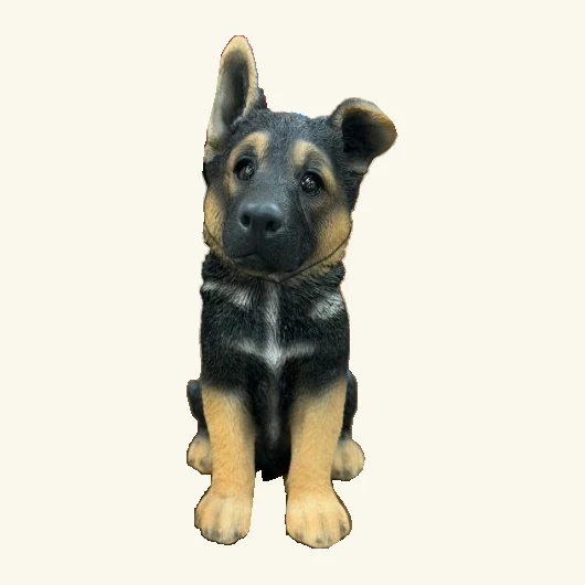 Seated black-and-tan German shepherd puppy figurine with one upright ear, one folded ear, detailed fur and its original tag cord.
