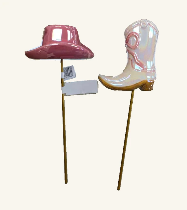 Actual two-piece Giddy Up plant-stick set: glossy pink cowboy hat and iridescent pink boot on their original gold-tone stakes, with attached hat-stake labels retained