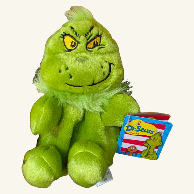 Actual green Grinch Smirk plush with its embroidered expression, neck fur, original Dr. Seuss paper tag and fabric label