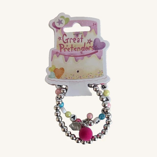 Happy Birthday set of two bracelets with colorful letter beads, silver-toned beads, a pink pom-pom and cupcake charm on the complete cake-shaped card.