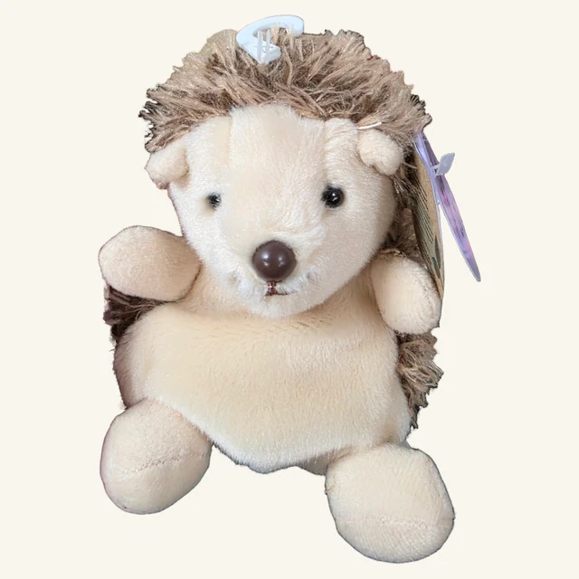 Actual cream-and-brown Hedgie hedgehog plush with visible side spines, crown fastener and original hanging paper tags