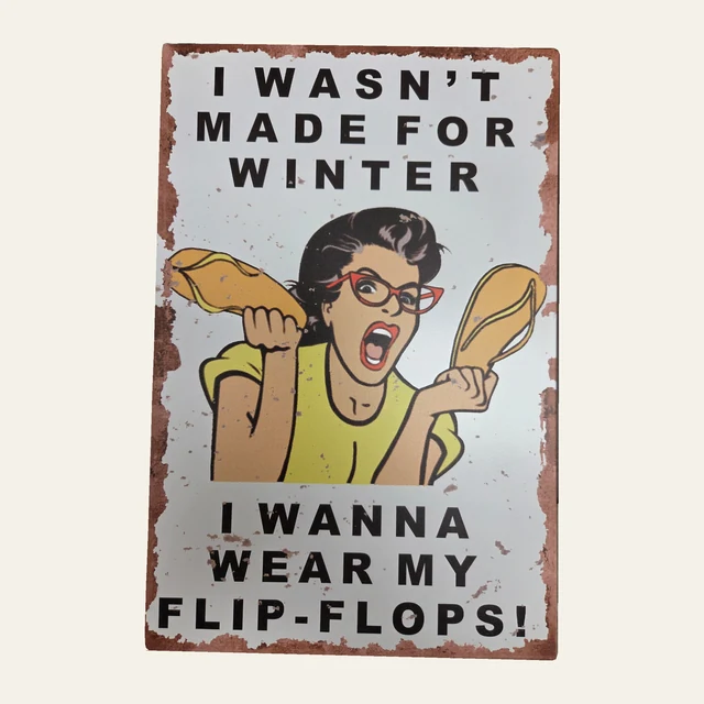 Tin sign reading I WASN'T MADE FOR WINTER I WANNA WEAR MY FLIP-FLOPS!, with a retro-style woman holding yellow flip-flops and a distressed-look border.