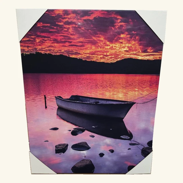 Complete Molten Morning artwork showing a moored boat and foreground rocks reflected in pink-purple water beneath a bright orange and magenta sky, retaining all four original white protective corners