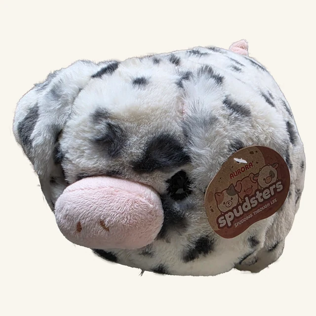 Actual rounded gray-and-white Pierre spotted pig plush with pink snout, original Spudsters tag and visible fabric underside