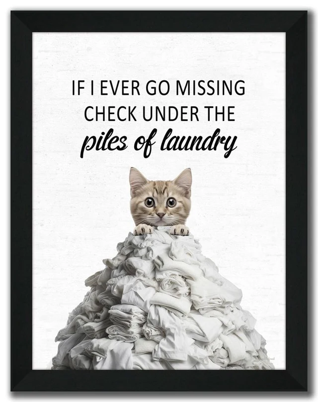 Complete black-framed Piles of Laundry Cat artwork with a kitten peeking over white linens and the original laundry-themed wording