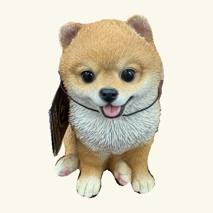 Tan-and-white sitting Pomeranian puppy figurine with a hanging tag and neck cord.