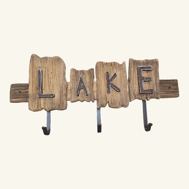 Rustic wood wall-hook rail with four raised metal letters spelling LAKE and three dark metal hooks