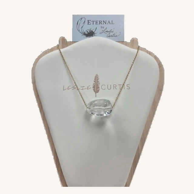 Sabina fine gold-tone chain necklace with a horizontal irregular clear stone centerpiece on its original Leslie Curtis display