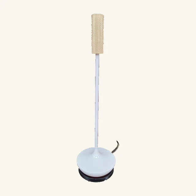 Complete Sleek table lamp with a textured gold-tone cylindrical shade, slender white stem, round white base and original black charging base and visible cord