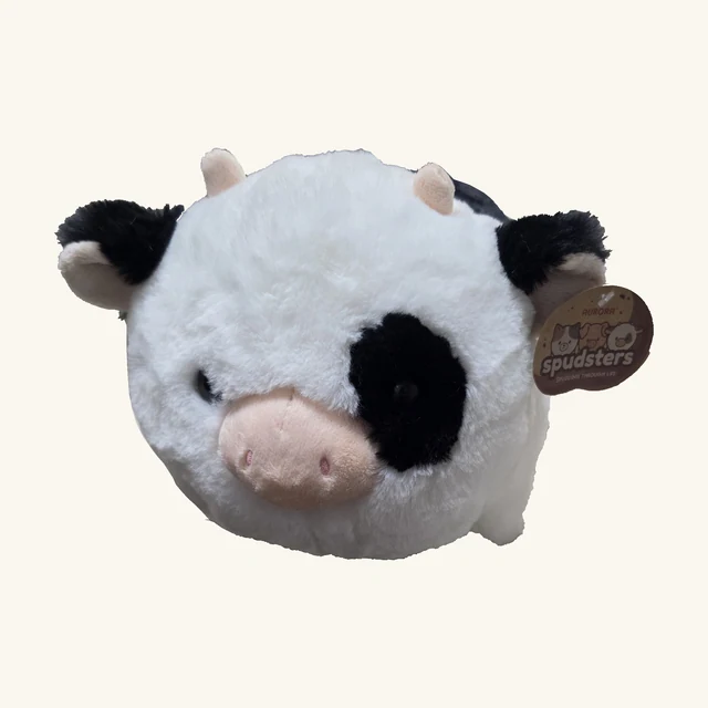 Round white Tutie Cow plush with black patches, pink horns and snout, short legs and its original attached Spudsters tag