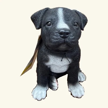 Black-and-white Staffordshire puppy figurine with its original hang tag and cord.
