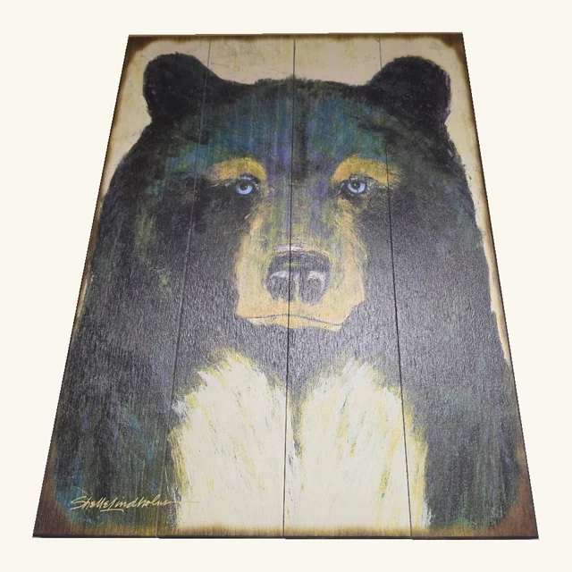 Timber wall artwork showing a front-facing black bear with blue eyes and a pale chest across vertical slats.
