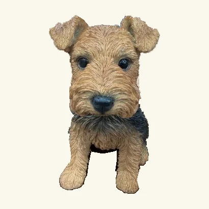 Tan-and-black Welsh terrier puppy figurine with folded ears, textured fur, dark eyes and its original small hanging tag edge.