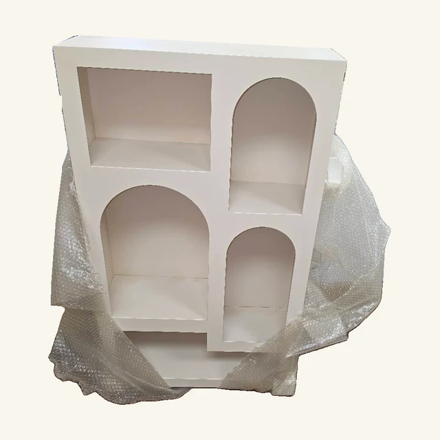 White Geometric Arch Cabinet Shelf. A mix of arched and square recesses gives this white display shelf a sculptural way to show small favorites.