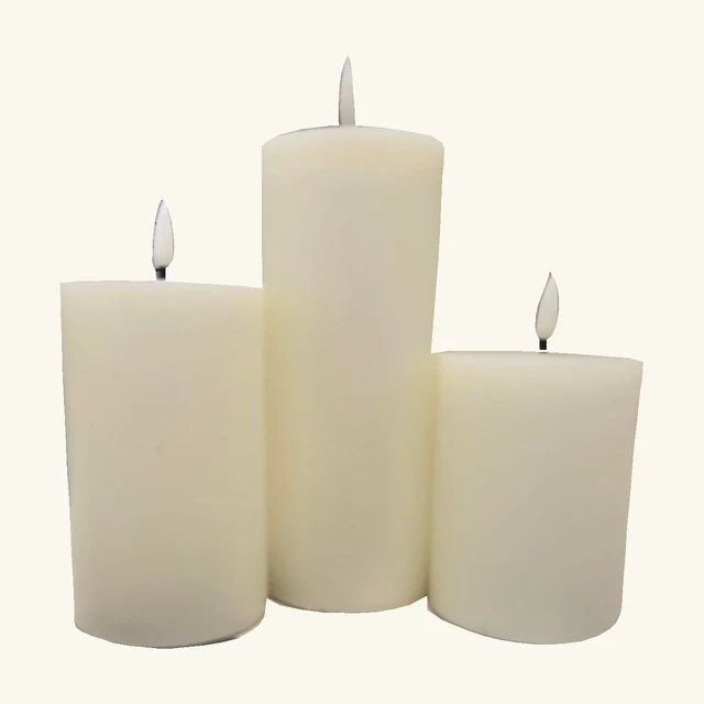 Three ivory-white LED pillar candles in graduated heights with flat flame-shaped inserts