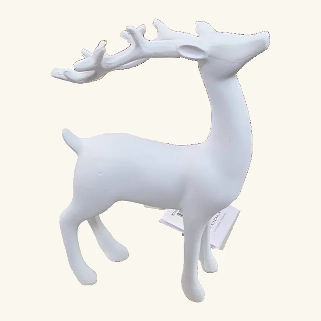 Representative white reindeer figurine with a raised head, complete branching antlers, four legs, small tail and original attached tag; assorted sizes sold individually.