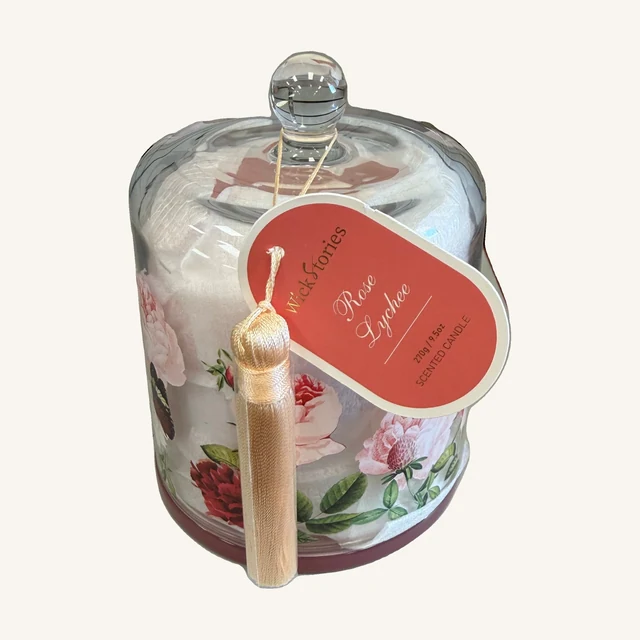Wick Stories Rose & Lychee Cloche Candle — 9.5 oz. Bring a rose-and-lychee fragrance to your space with a floral candle presented under a clear glass cloche.
