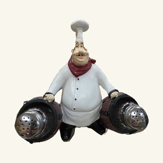 One white-coated chef with a red neckerchief holding two silver-capped shakers in brown barrel-style cradles